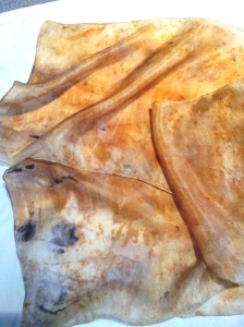 Scarf over-dyed with tea on eucalyptus dyed silk. Dark grey spots from rust.